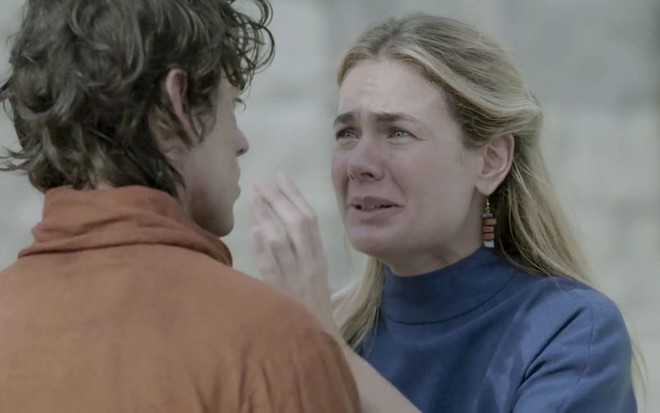 Thaís Pacholek grava cena chorando com Vinícius Redd, que aparece de costas, como Marílis e Ézer, da novela Reis