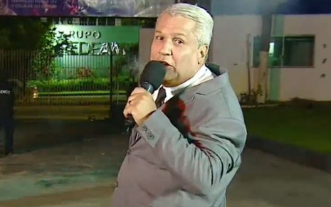 Na área externa da TV A Crítica, Sikêra Jr. segura microfone enquanto comanda o Alerta Nacional