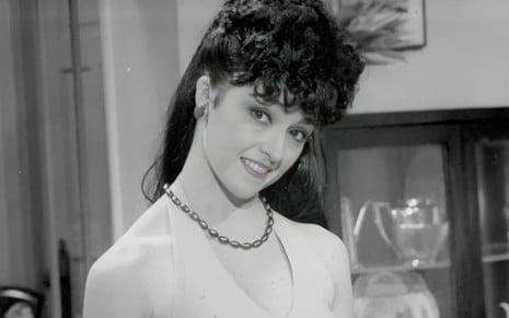 Regina Restelli como sua personagem na novela Bambolê (1987), em foto preto e branca, sorrindo