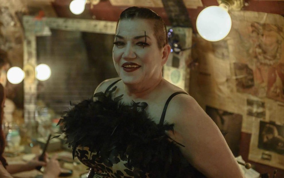 Lea DeLaria usa uma roupa bufante e maquiagem carregada em cena de Reprisal