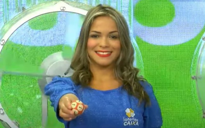 Modelo contratada pela Caixa segura bolinha com número em sorteio das loterias