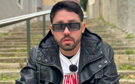 Rico Melquíades em foto publicada em seu Instagram, com expressão séria, jaqueta de couro e óculos escuros