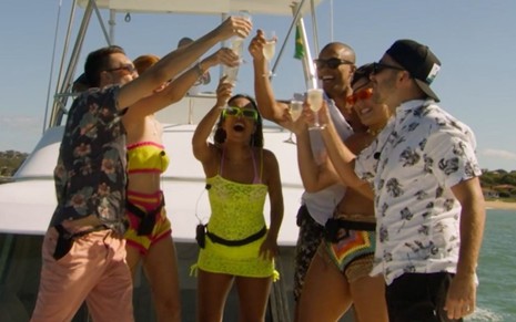 Imagem dos participantes do Rio Shore com taças levantadas durante uma festa em um barco
