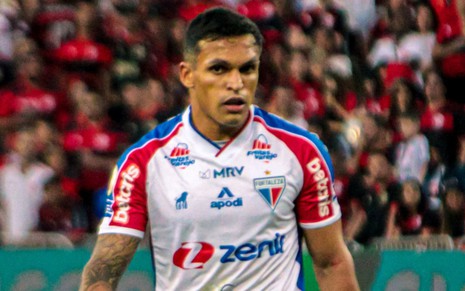 Robson, do Fortaleza, joga pelo clube com uniforme branco com detalhes vermelhos e azuis