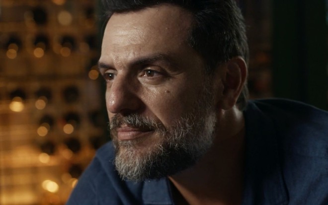 Em cena de Travessia, Rodrigo Lombardi está com a expressão de empáfia, olhando para alguém