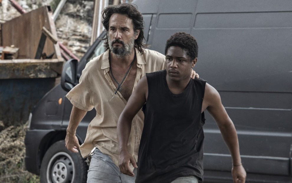 Com expressão de raiva, Rodrigo Santoro conduz Christian Malheiros em cena do filme 7 Prisioneiros