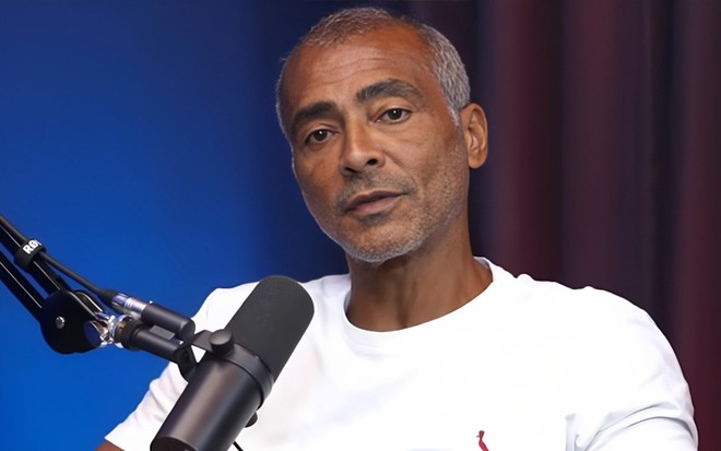 Foto de Romário; ele está em um podcast e veste camiseta branca