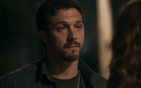 O ator Romulo Estrela com expressão de choro em cena de Travessia