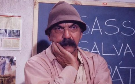 Lima Duarte com a mão no queixo e expressão séria; ele está caracterizado como Sassá Mutema da novela O Salvador da Pátria