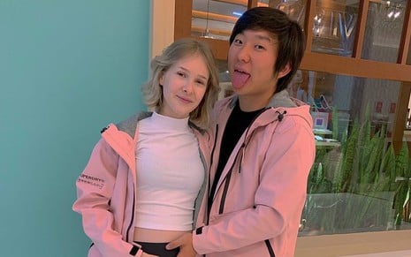 Sammy Lee e Pyong Lee usando casacos rosa, abraçados