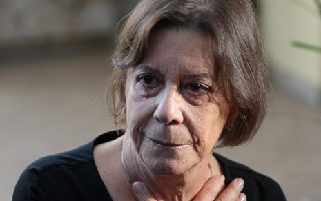 Sandra Buzzi com lágrimas nos olhos e expressão triste, blusa preta, durante velório de Palmirinha Onofre