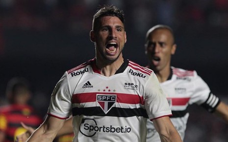 Jogador Calleri, do São Paulo, veste uniforme branco com detalhes preto e vermelho e comemora gol