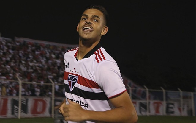 Jogador Maioli, do São Paulo, comemora gol e veste uniforme branco com detalhes vermelho e preto