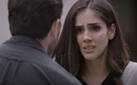 Sandra Echeverría grava cena com expressão desesperada para Arap Bethke, que aparece de costas, como Paulina e Nava em A Usurpadora, do SBT