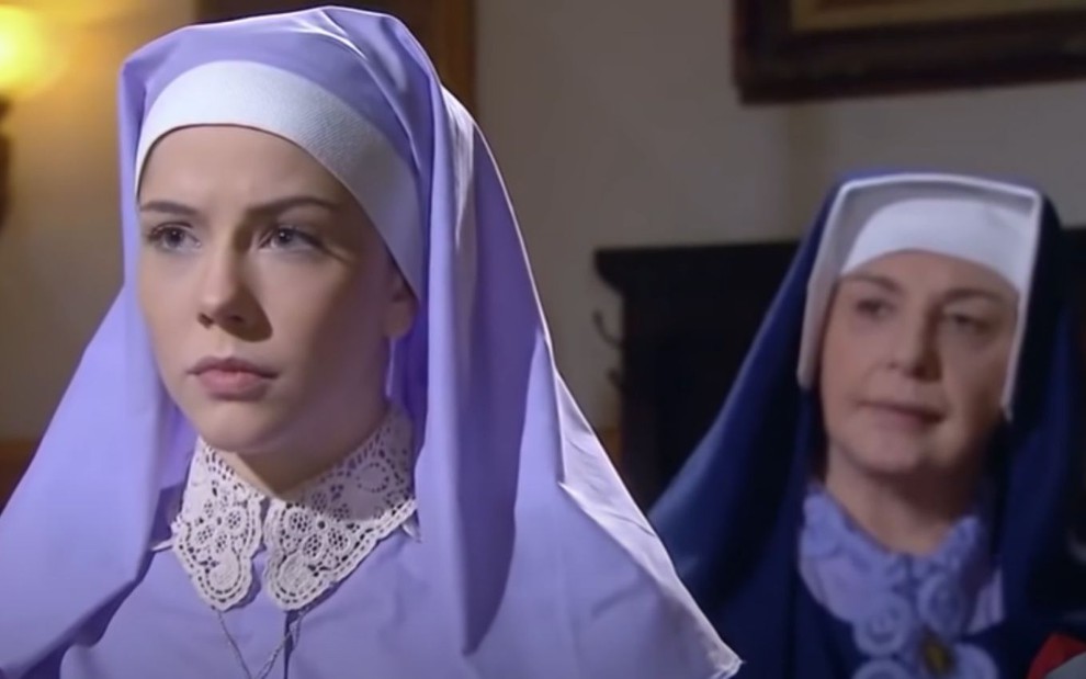 Bia Arantes grava cena com expressão tensa ao lado de Eliana Guttman, como Irmã Cecília e Madre Superiora em Carinha de Anjo