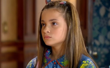 Raissa Chaddad grava cena com cabelo solto e expressão séria em Chiquititas, como Bia