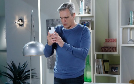 Otto (Dalton Vigh) olha o celular em cena de Poliana Moça