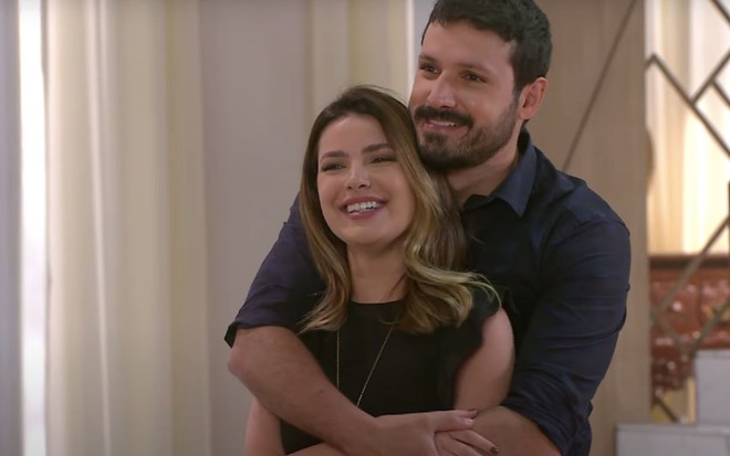 Os personagens Luísa (Thaís Melchior) e Marcelo (Murilo Cezar) sorriem abraçados na novela Poliana Moça, do SBT