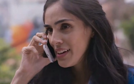A atriz Sandra Echeverria sorri falando ao telefone como a personagem Paulina em cena da novela mexicana A Usurpadora