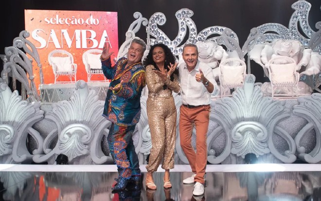 Milton Cunha, Teresa Cristina e Luís Roberto juntos no palco do Seleção do Samba, posando alegremente para uma foto