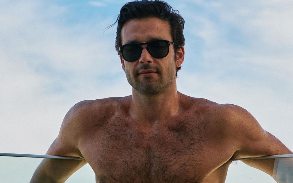 Sergio Marone em foto publicada no Instagram; o ator está sem camisa, se apoiando em uma varanda e usa um óculos escuros