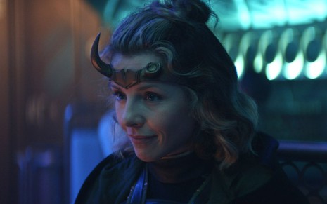 Sylvie (Sophia Di Martino) de jaqueta e arco com um dos chifres quebrados olhando para a esquerda em cena da série Loki