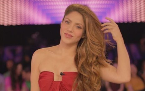 Imagem de Shakira de cabelo solto e top tomara que caia vermelho