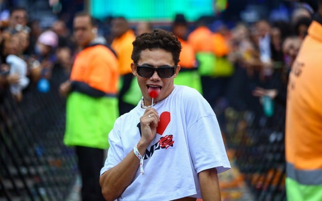 Silvero Pereira aparece em um festival de música no Rio de Janeiro usando look estiloso e chupando pirulito