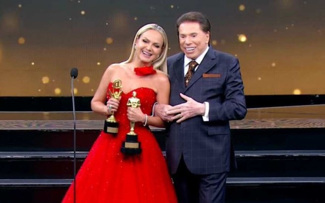 Eliana e Silvio Santos sorridentes no palco do Troféu Imprensa