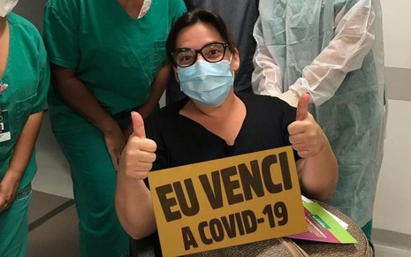 Imagem de Simone Gutierrez no hospital segurando uma placa dizendo "eu venci a Covid-19"