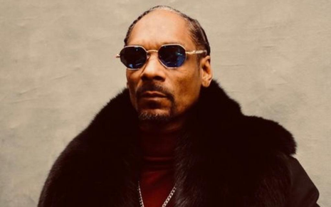 O rapper norte-americano está de óculos escuros e usa um casaco de pelo marrom