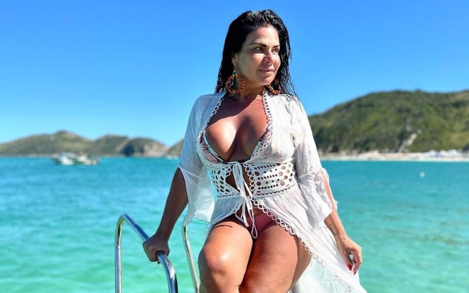Solange Gomes usa biquíni e saída de banho brancos e posa para foto com fundo paradisíaco