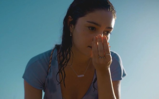 Sophie Charlotte cheira algo nas mãos em cena como Maíra na novela Todas as Flores