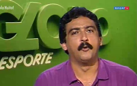 Com camisa polo roxa, Galvão Bueno está no cenário do Globo Esporte com um bigode