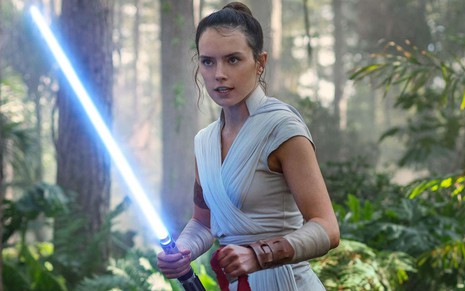 Daisy Ridley segura um sabre de luz e tem expressão de raiva em cena de Star Wars