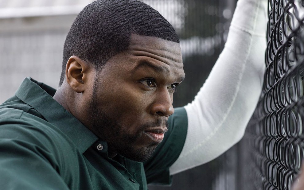 O rapper 50 Cent está com roupa de presidiário e apoiado em grade em cena da série Power