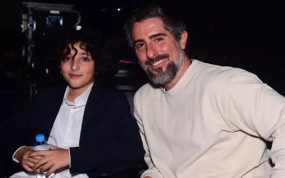Stefano Mion com um blazer preto e o pai com uma camisa branca