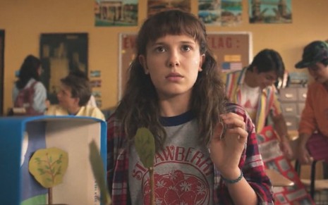 Eleven (Millie Bobby Brown) no novo teaser de Stranger Things 4; ela está em uma sala de aula