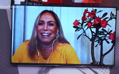 Susana Vieira sorri e está com uma blusa amarela em entrevista por chamada de vídeo no Altas Horas