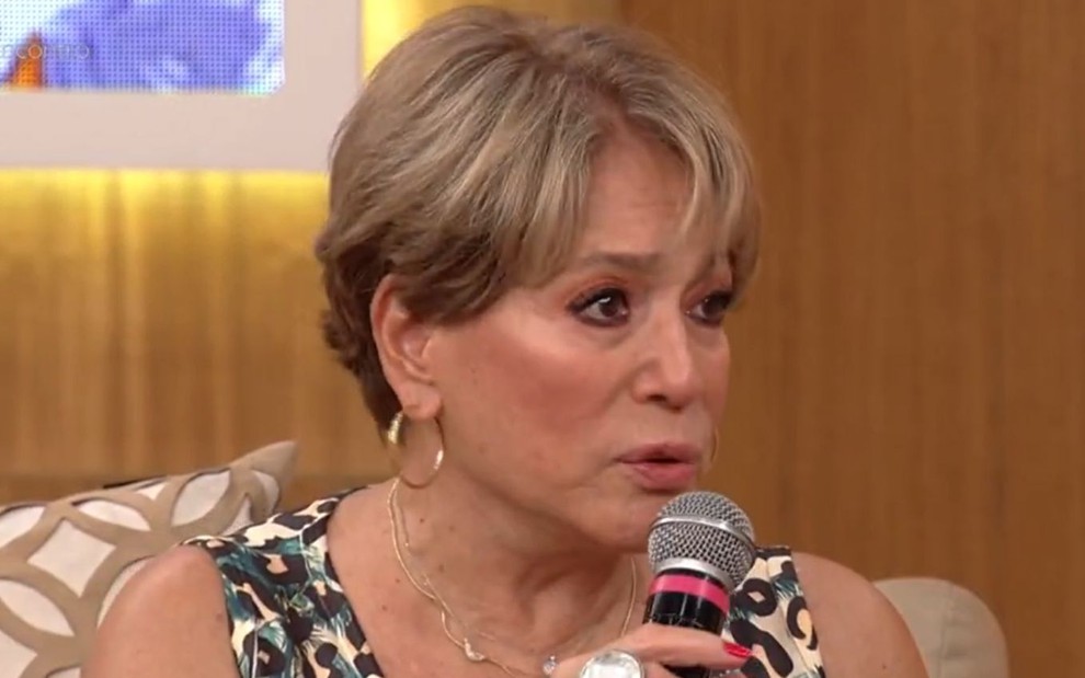 A atriz Susana Vieira dá uma entrevista e segura o microfone com a mão direita no Encontro, da Globo