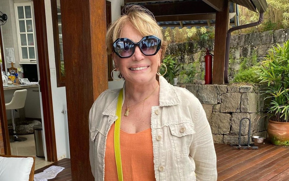A atriz Susana Vieira; ela está posando para a foto com um óculos de sol e sorrindo