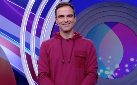 Tadeu Schmidt de casaco vermelho enquanto apresenta o BBB 22, da Globo