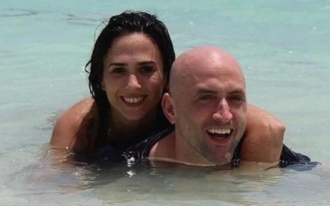 Tatá Werneck e Paulo Gustavo estão abraçados em meio às águas de uma praia