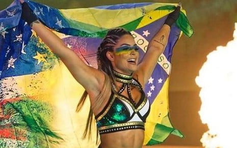 Tay Conti em evento da AEW com metade da bandeira do Brasil e dos Estados Unidos