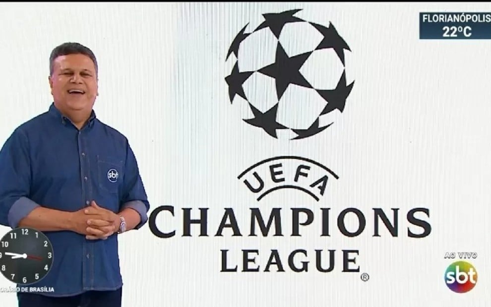 Téo José, ao lado do logotipo da Champions League, com uma camisa azul e anunciando a transmissão do principal evento de futebol do mundo