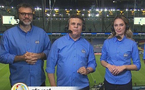 Téo José, Mauro Beting e Nadine Basttos em uma transmissão do SBT, todos com uma camisa azul e apresentando um jogo na Copa América
