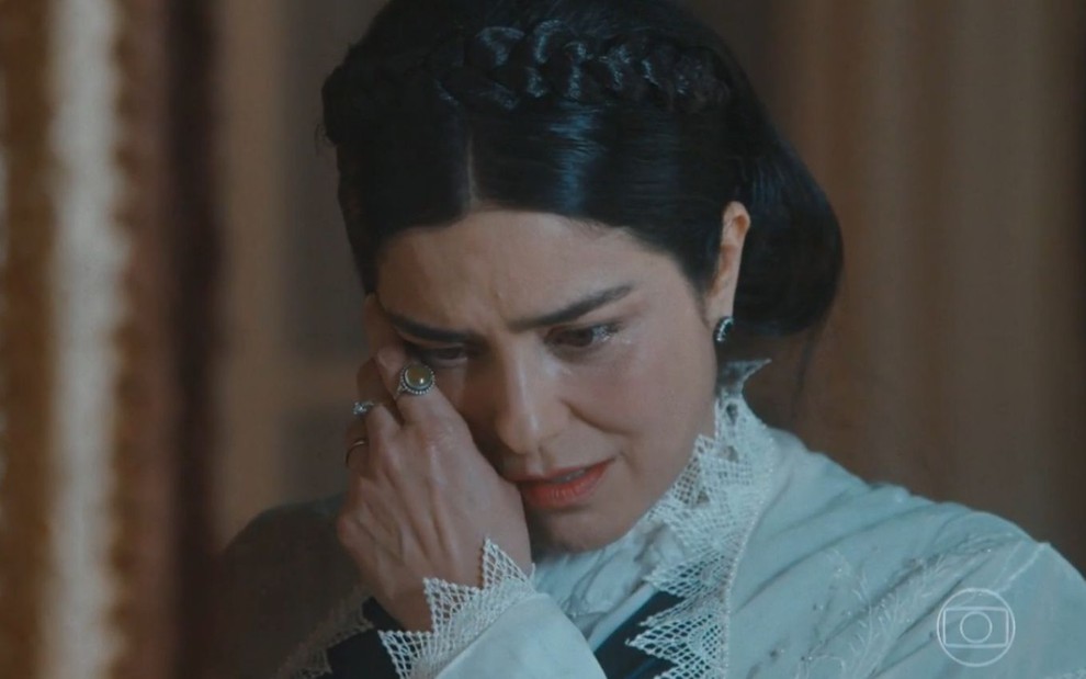 Atriz Leticia Sabatella olha para baixo e simula choro em cena de Nos Tempos do Imperador