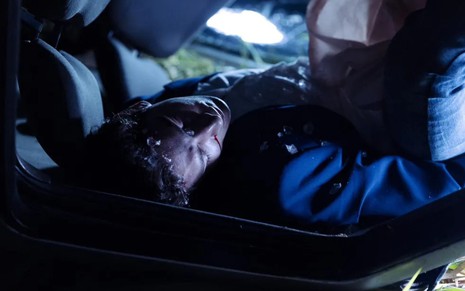 Daniel (Johnny Massaro) desmaiado dentro de um carro capotado em Terra e Paixão