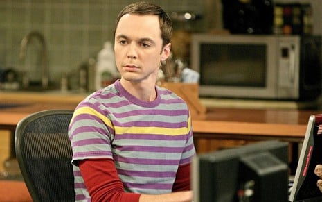 Jim Parsons em cena com uma camisa roxa na série The Big Bang Theory