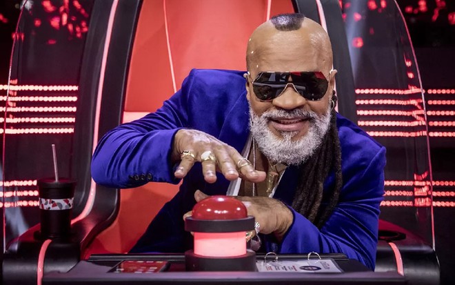 Carlinhos Brown apertando botão no The Voice Brasil, da Globo